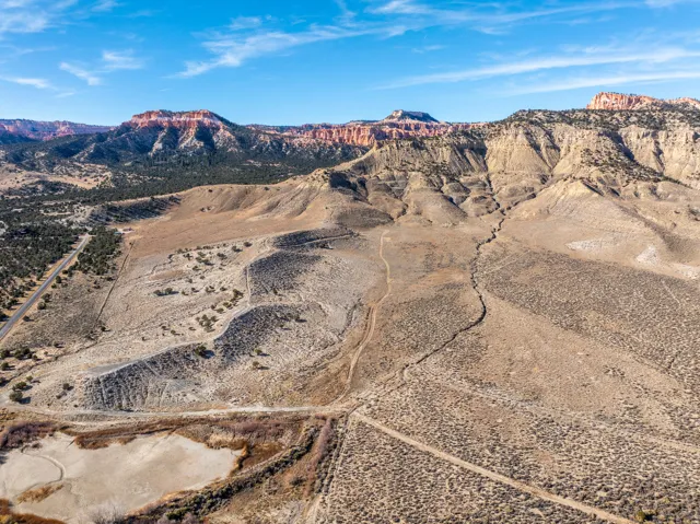 Expansive, undeveloped desert landscape featuring varied topography, including flat terrain, rolling hills, and deep canyons