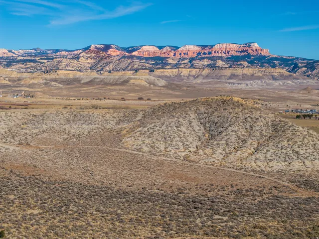 Expansive desert landscape featuring rolling hills and distant mountains