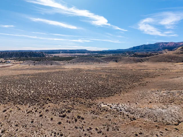 Expansive undeveloped land featuring natural terrain with distant mountain ranges and a wide-open sky