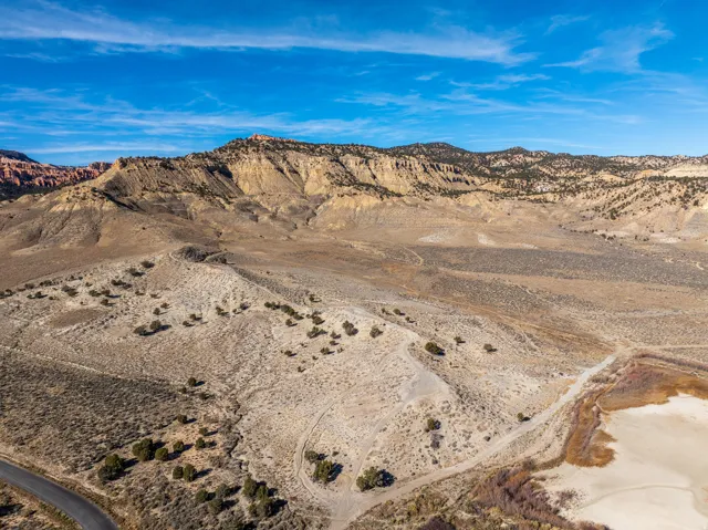 Expansive desert landscape featuring rugged mountain terrain, natural rock formations, and varied ground cover