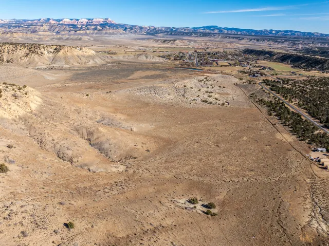 Expansive desert landscape featuring varied topography with distant mountain ranges