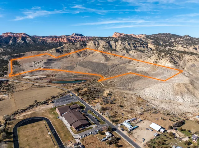 Expansive land parcel featuring natural terrain and distant mountain ranges under a clear sky