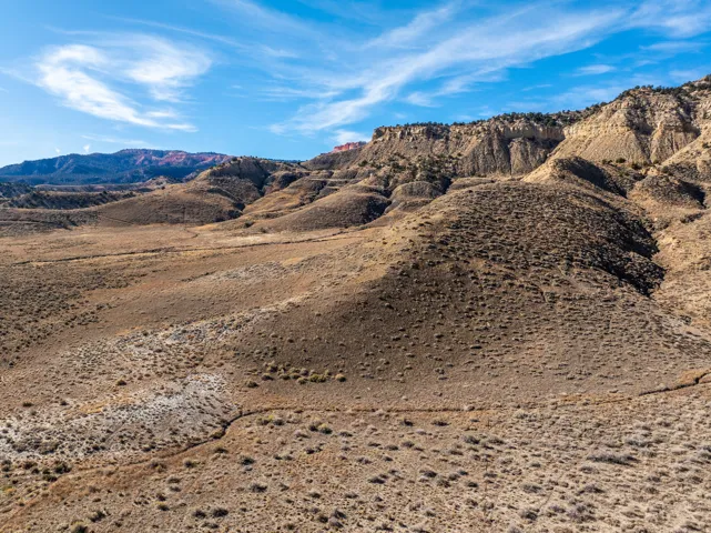 Expansive rugged landscape featuring undulating terrain and distant mesa formations