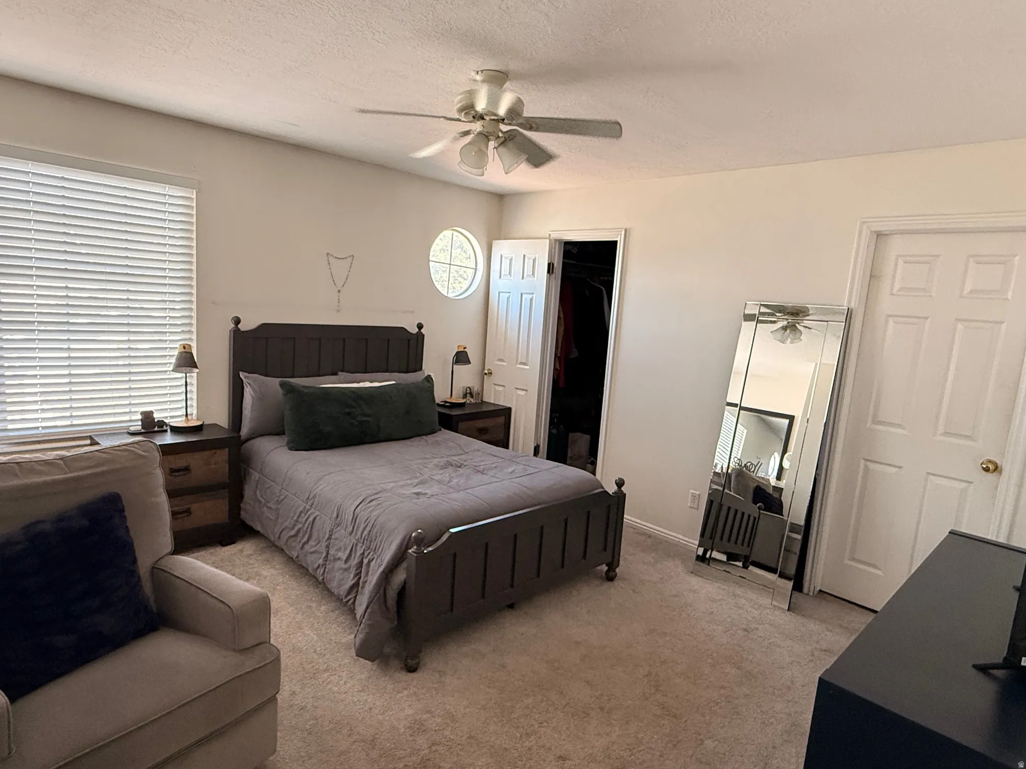 Carpeted bedroom with a ceiling fan