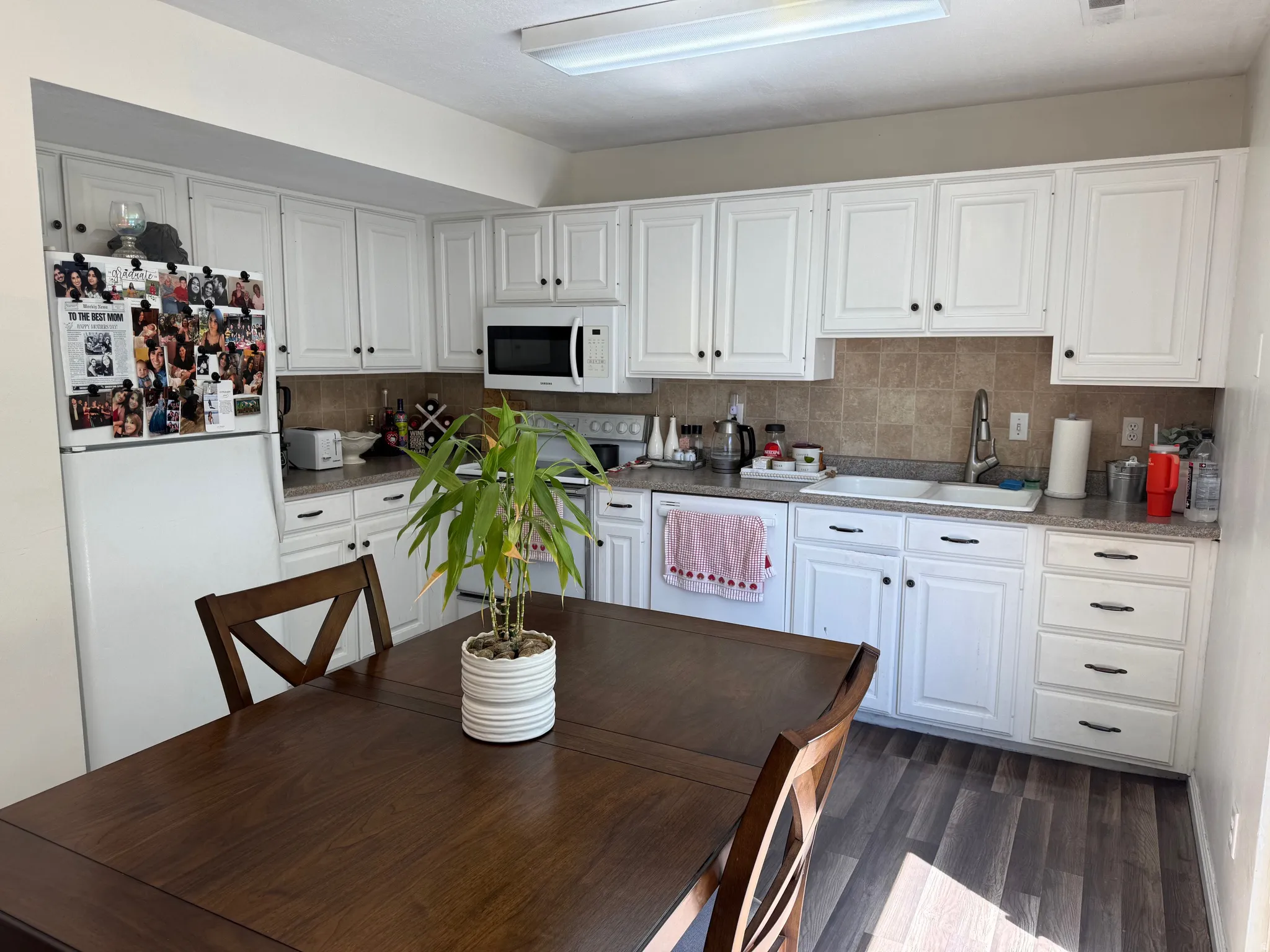 Kitchen featuring white cabinetry, a tiled backsplash, and wood-finish flooring