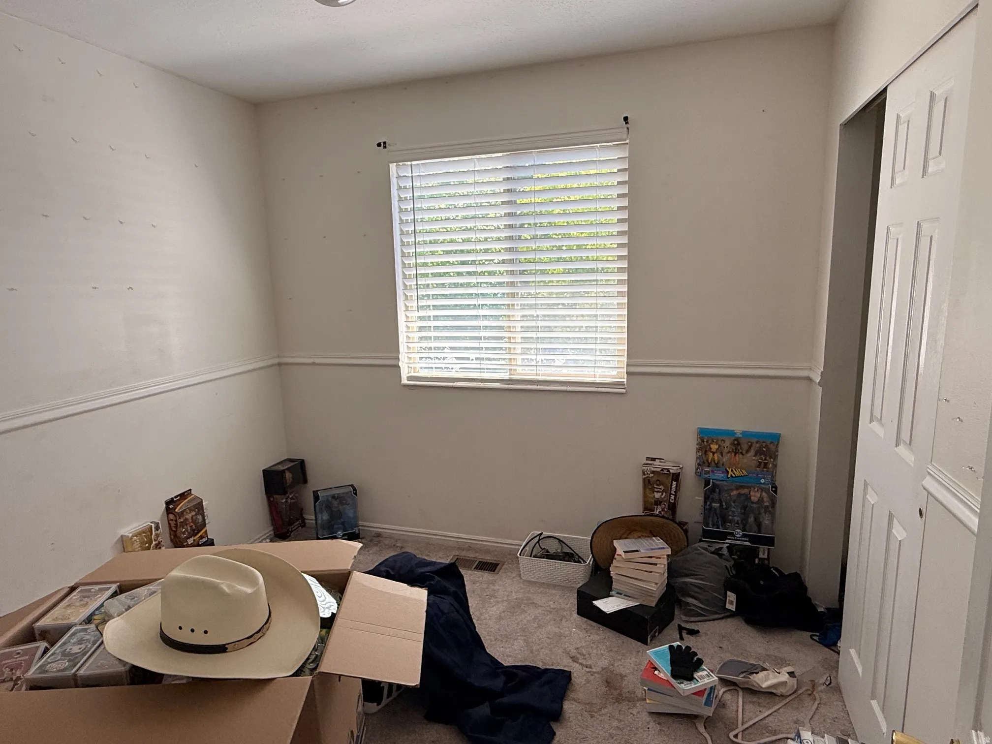 Room featuring neutral walls with chair rail molding, a window with horizontal blinds, and recessed ceiling lighting