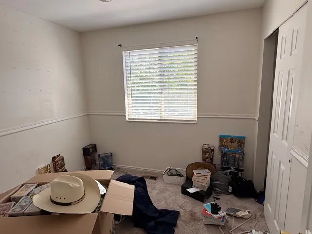 Room featuring neutral walls with chair rail molding, a window with horizontal blinds, and recessed ceiling lighting