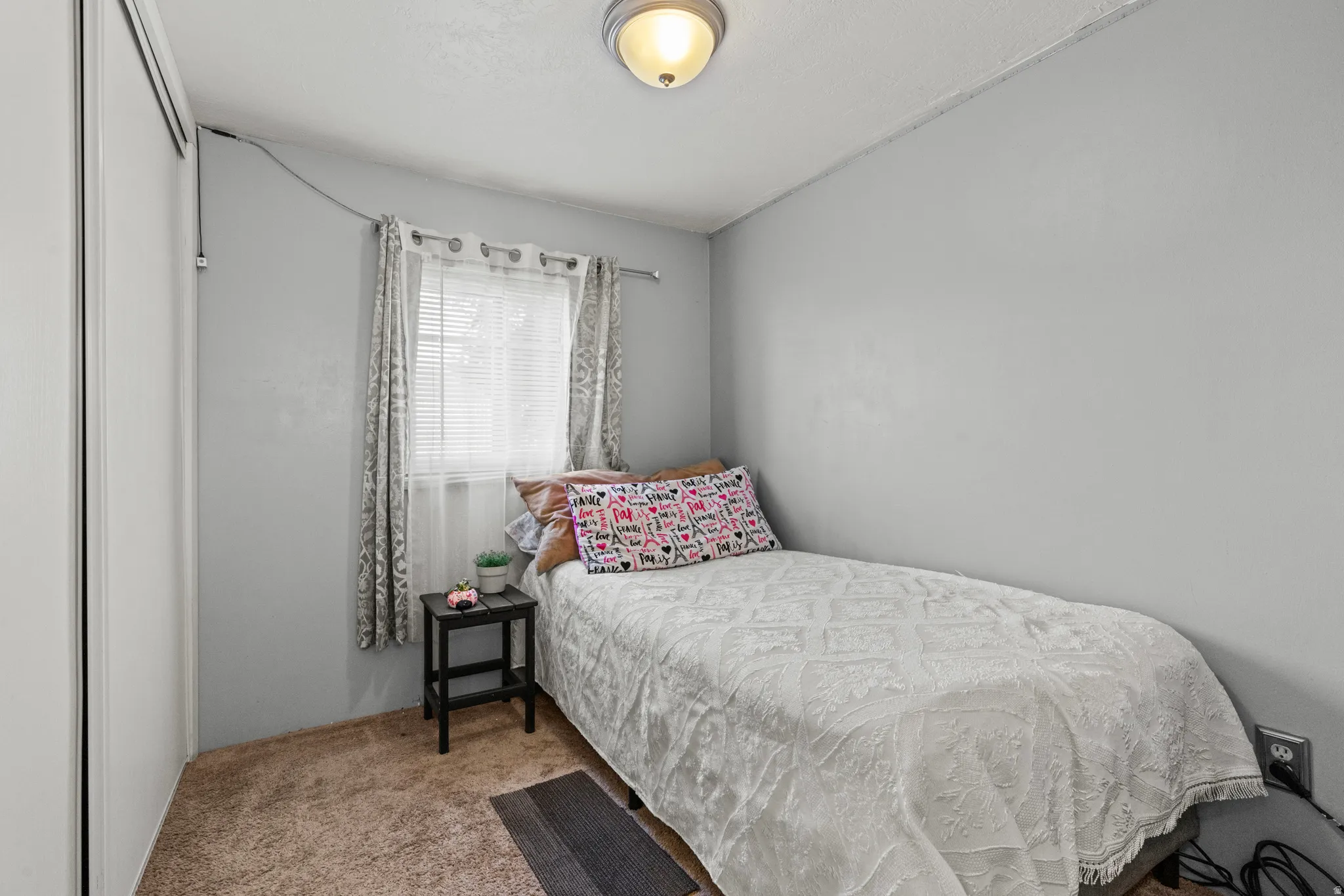 Room with light gray walls, textured ceiling, and brown carpet flooring