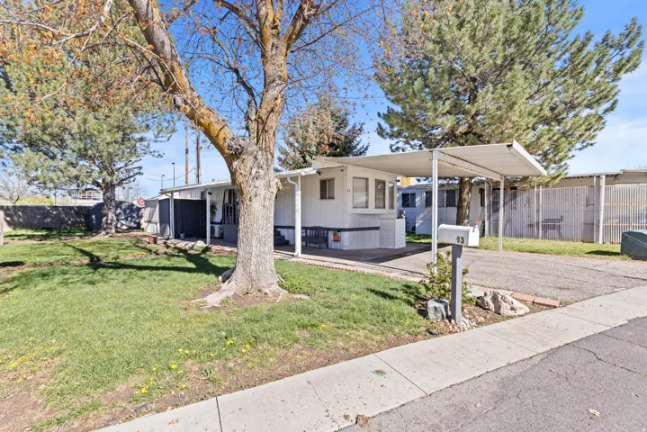 Property exterior featuring white siding and a covered carport