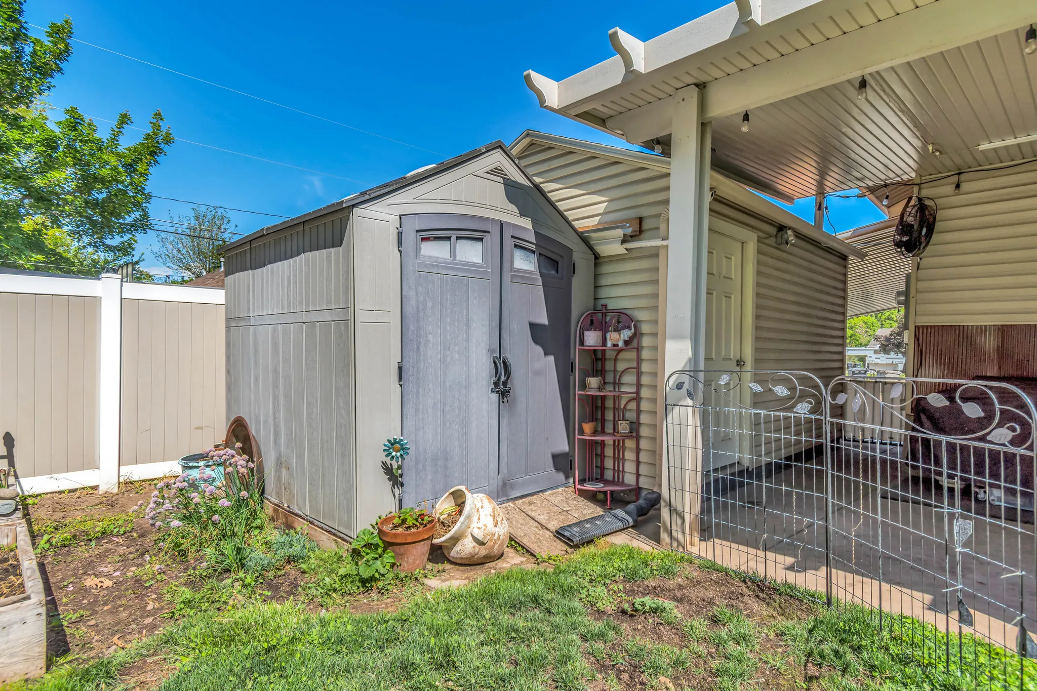 Backyard featuring a shed, covered patio, and privacy fencing