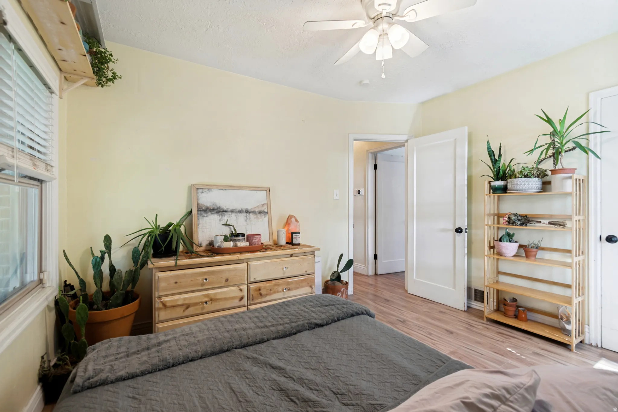 Room featuring wood flooring, light-toned walls, and a ceiling fan