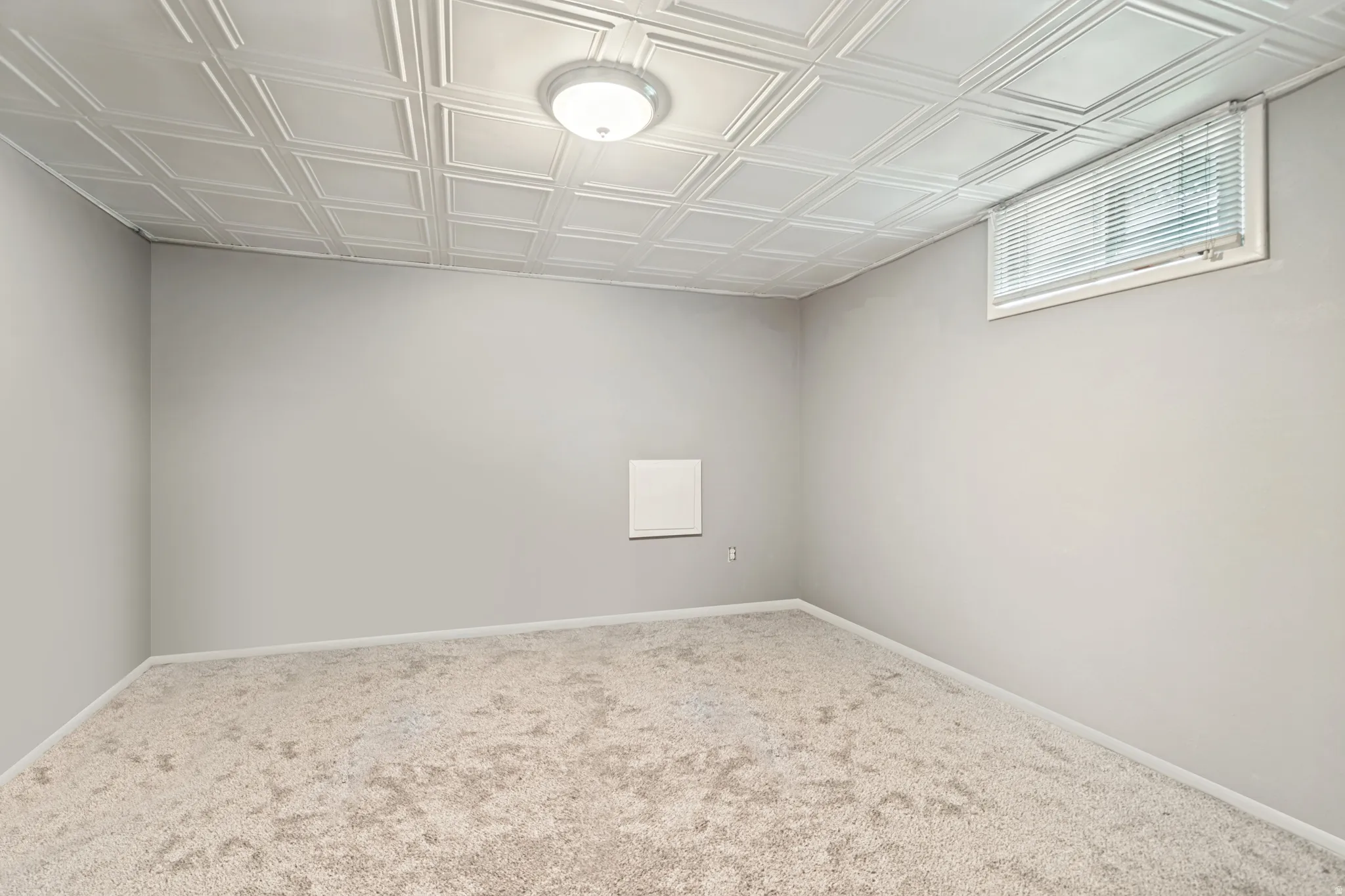 Room featuring textured ceiling panels and neutral wall paint