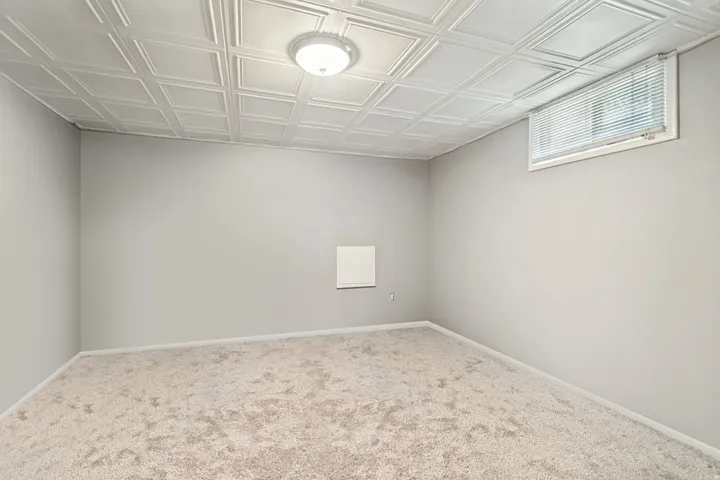 Room featuring textured ceiling panels and neutral wall paint