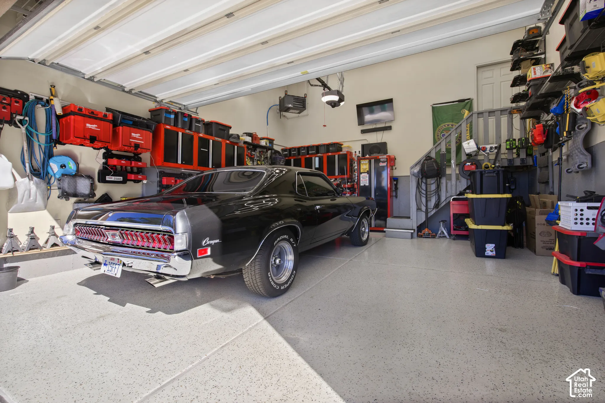 Spacious garage featuring a durable epoxy floor, built-in wall shelving, and overhead sectional doors
