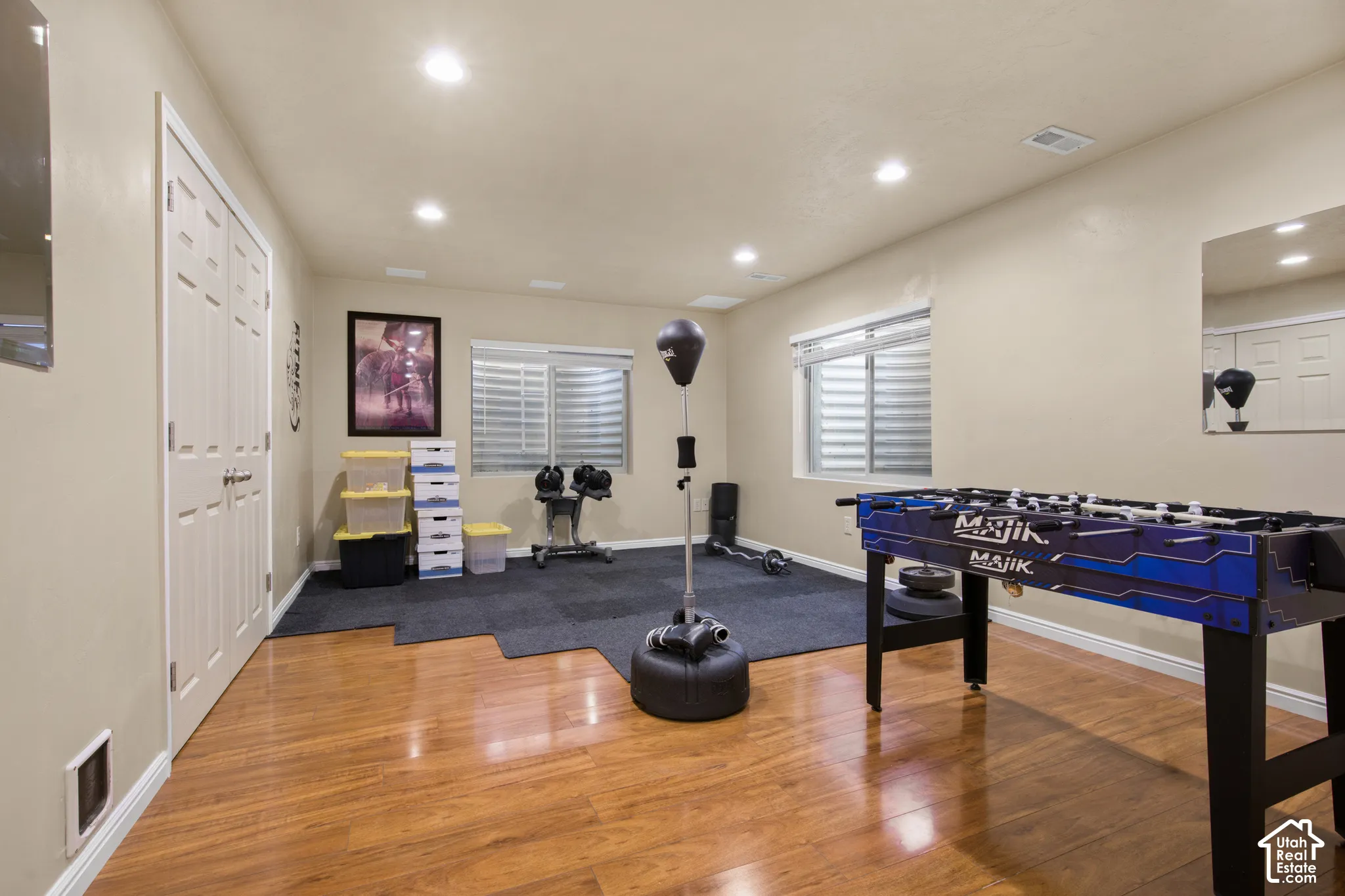 Versatile bonus room featuring wood-finish flooring, recessed lighting, and a window with horizontal blinds