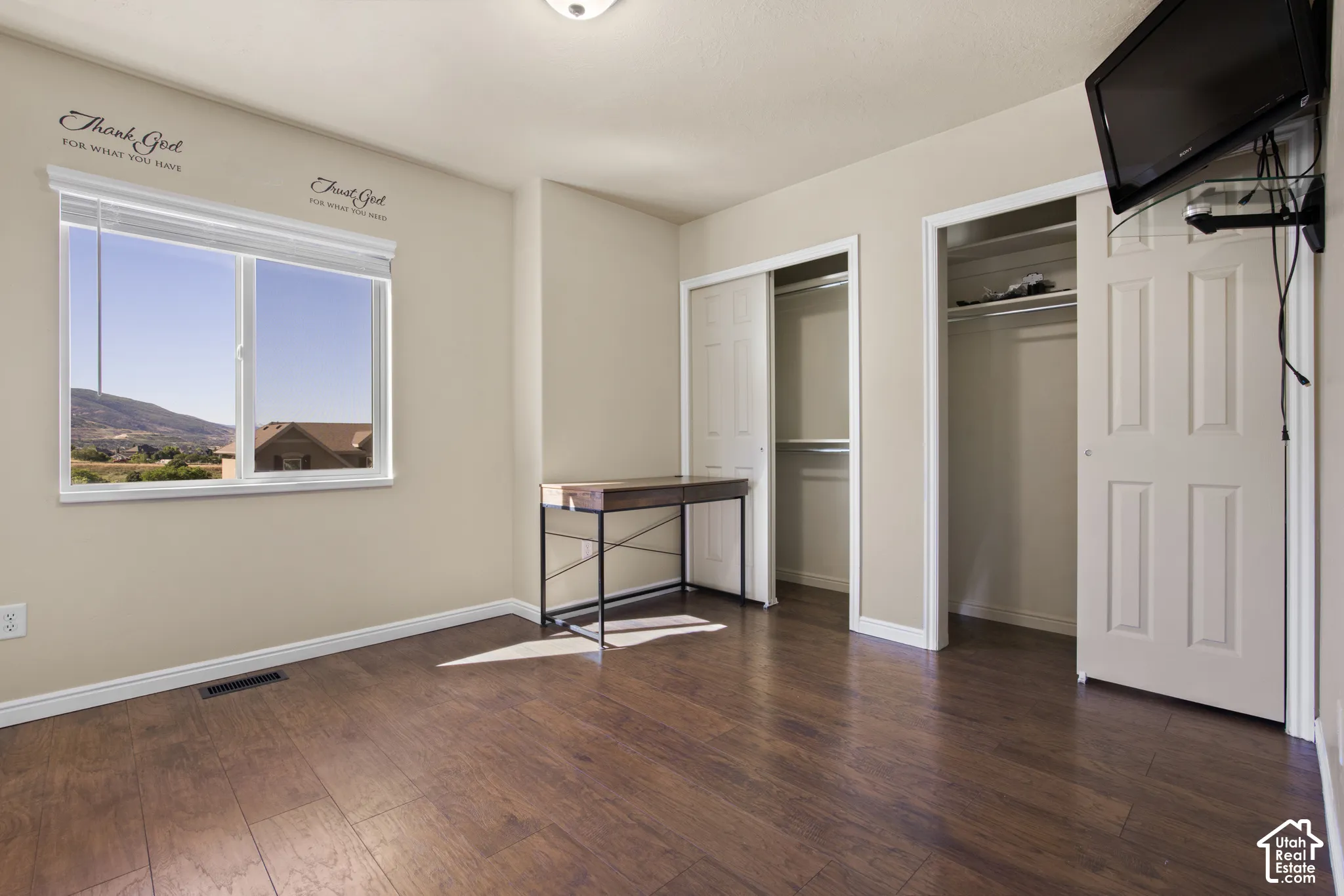 Spacious room featuring wood-finish flooring and two bi-fold door closets