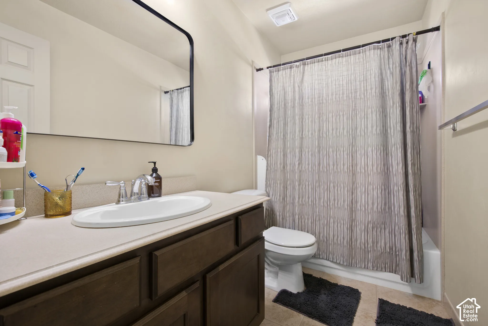 Bathroom featuring a dark wood-finish vanity with a light-colored countertop and an undermount sink
