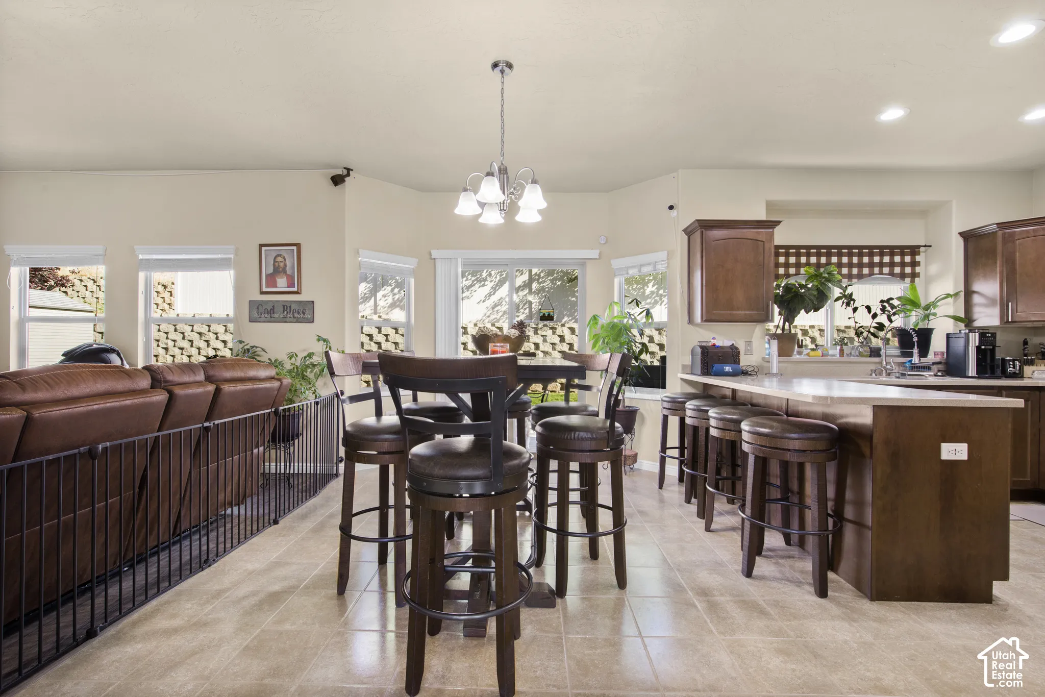 Open-concept living area featuring a kitchen island with seating, a separate dining area, recessed lighting, and tile flooring