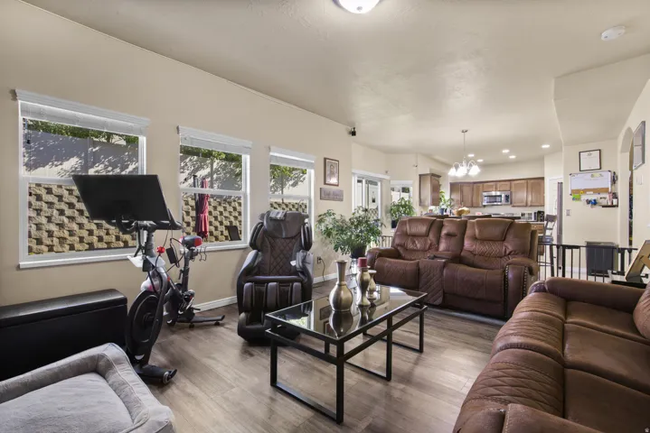 Open-concept living area featuring wood-finish flooring and multiple windows with white blinds