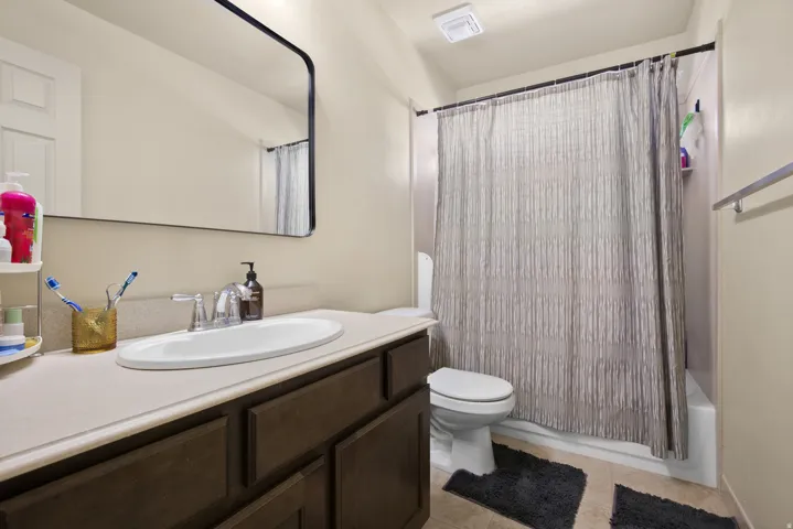 Bathroom featuring a dark wood-finish vanity with a light-colored countertop and an undermount sink