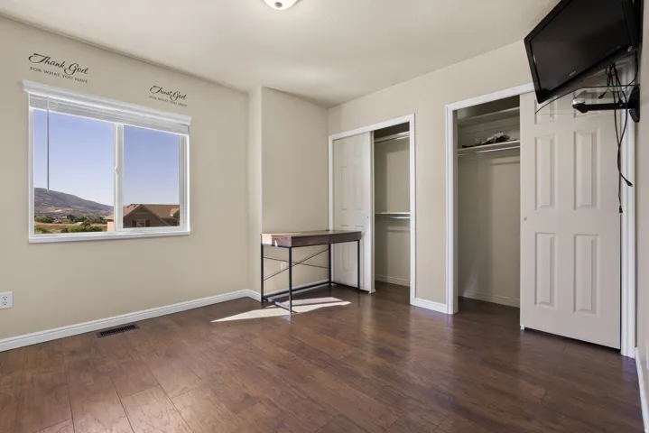 Spacious room featuring wood-finish flooring and two bi-fold door closets