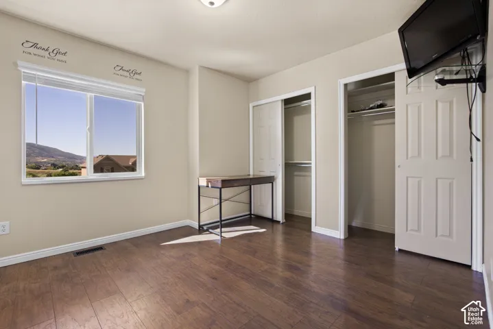 Spacious room featuring wood-finish flooring and two bi-fold door closets
