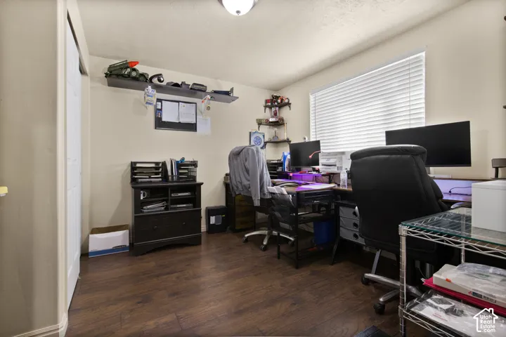 Room featuring wood-finish flooring, a double window with blinds, and light-colored walls