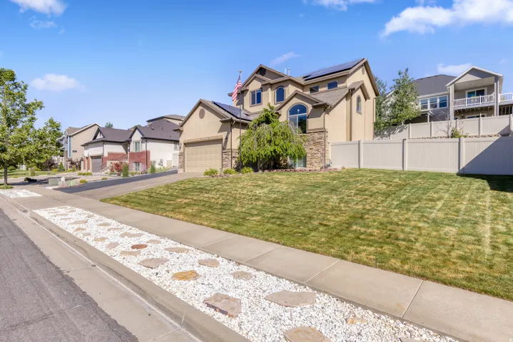 Stucco exterior with stone accents, an arched window, and solar panels