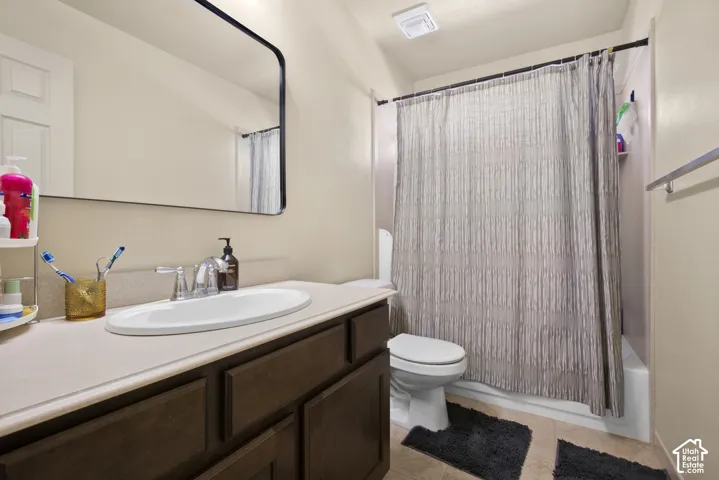 Bathroom featuring a dark wood-finish vanity with a light-colored countertop and an undermount sink