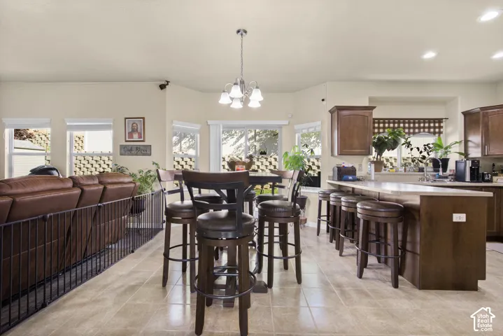 Open-concept living area featuring a kitchen island with seating, a separate dining area, recessed lighting, and tile flooring
