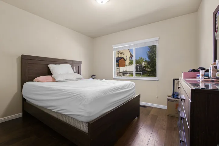 Bedroom featuring wood-finish flooring, a window with exterior views, and a ceiling light fixture
