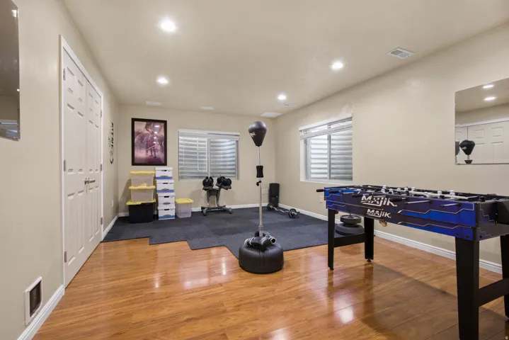 Versatile bonus room featuring wood-finish flooring, recessed lighting, and a window with horizontal blinds
