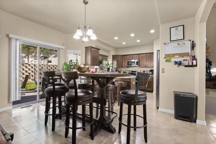 Open-concept kitchen and dining area featuring tile flooring and sliding glass door access to the backyard