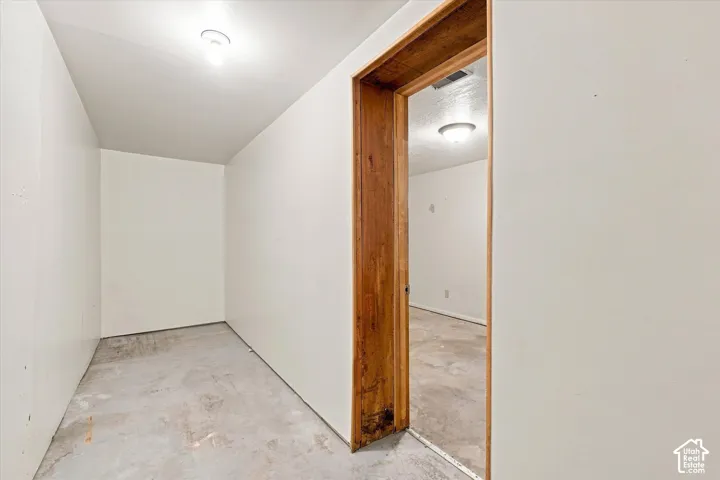 Interior space featuring concrete flooring, white painted walls, and overhead flush-mount lighting