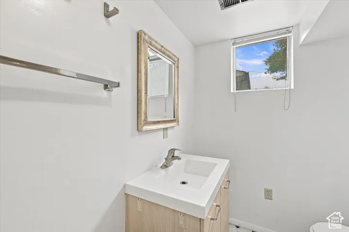 Modern vanity with integrated sink, chrome faucet, and wood-finish cabinetry