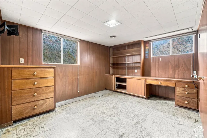 Built-in wood-finish cabinetry, integrated shelving, and a desk area
