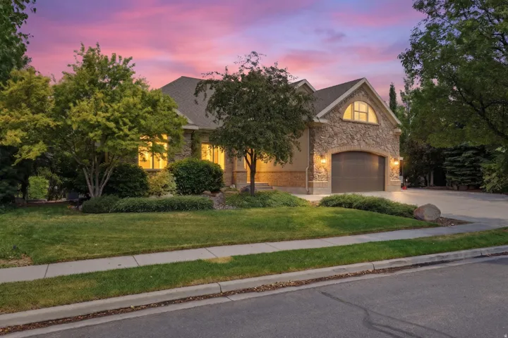 Stone and stucco exterior with a prominent arched garage door