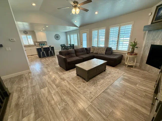 Open-concept living space with vaulted ceilings, recessed lighting, and wood-finish flooring