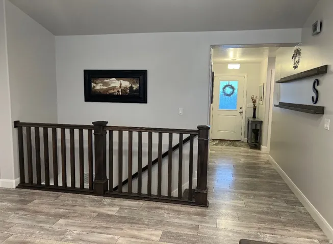 Contemporary wood-finish flooring extending through an open hall