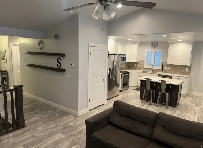 Open-concept living space with vaulted ceilings and wood-finish flooring