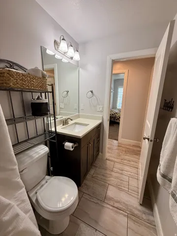 Bathroom featuring a single vanity with dark wood-finish cabinetry, a light-colored countertop, and an undermount sink