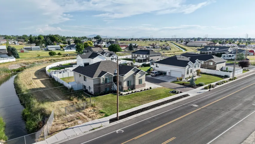 Contemporary residential property featuring a multi-gable roofline, a two-car garage, a paved driveway, and established landscaping