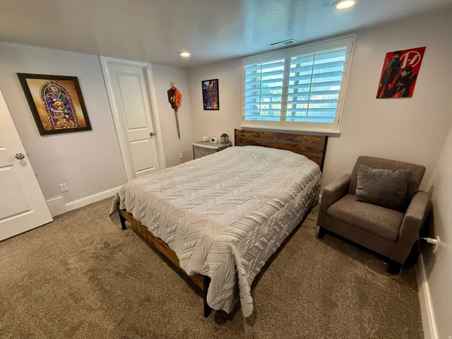 Bedroom featuring neutral-toned carpeting, recessed lighting, and white plantation shutters