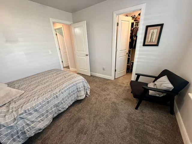 Neutral tone walls with white trim and a textured brown carpet