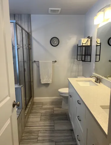 Modern bathroom featuring a double vanity with light-toned countertops and undermount sinks