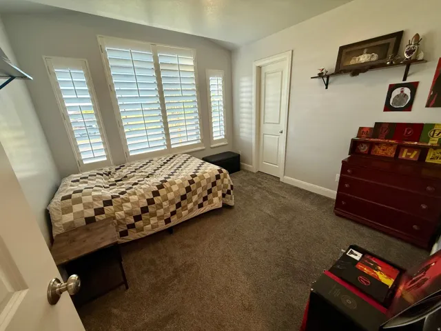 Interior room featuring plush gray carpeting, white baseboards, and light gray wall paint