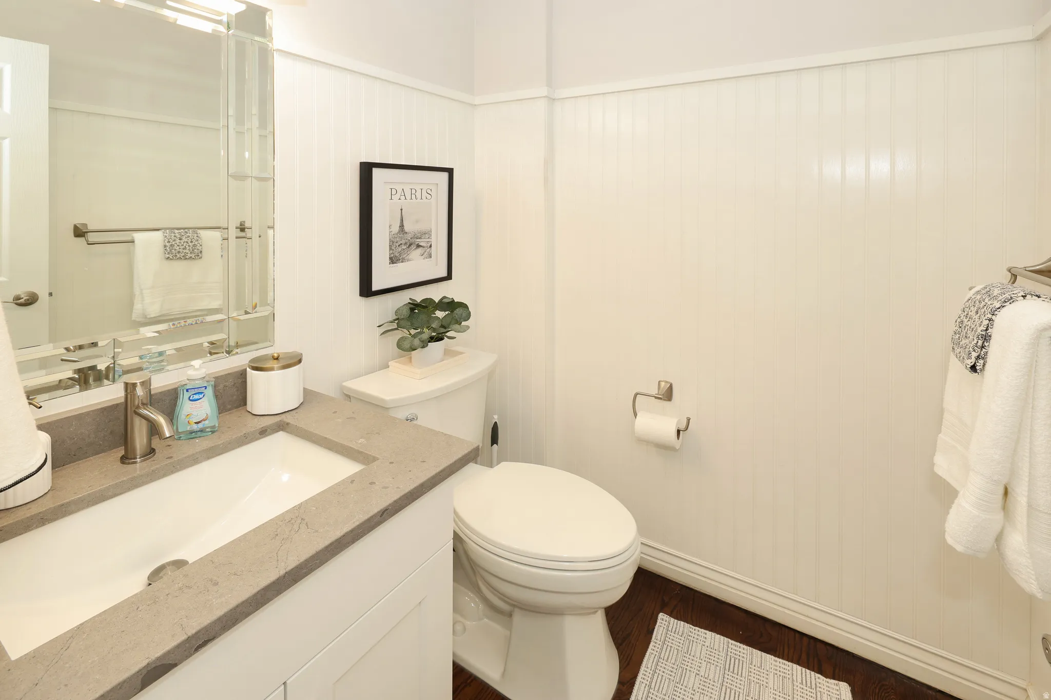 Bathroom featuring a single vanity with a rectangular basin, light-toned stone countertop, and brushed nickel faucet