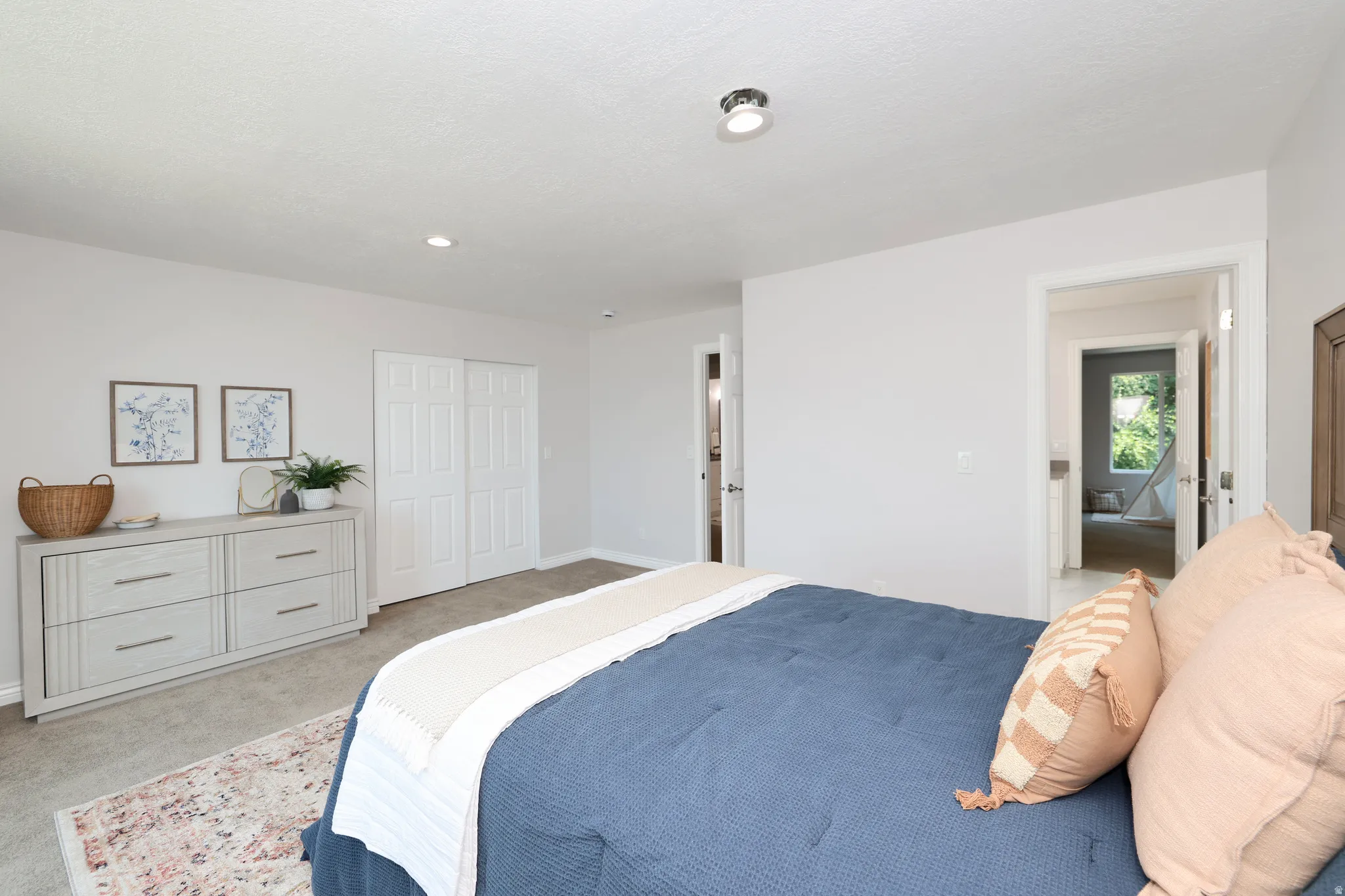 Carpeted bedroom featuring recessed lighting, a ceiling-mounted fixture, and white bi-fold closet doors