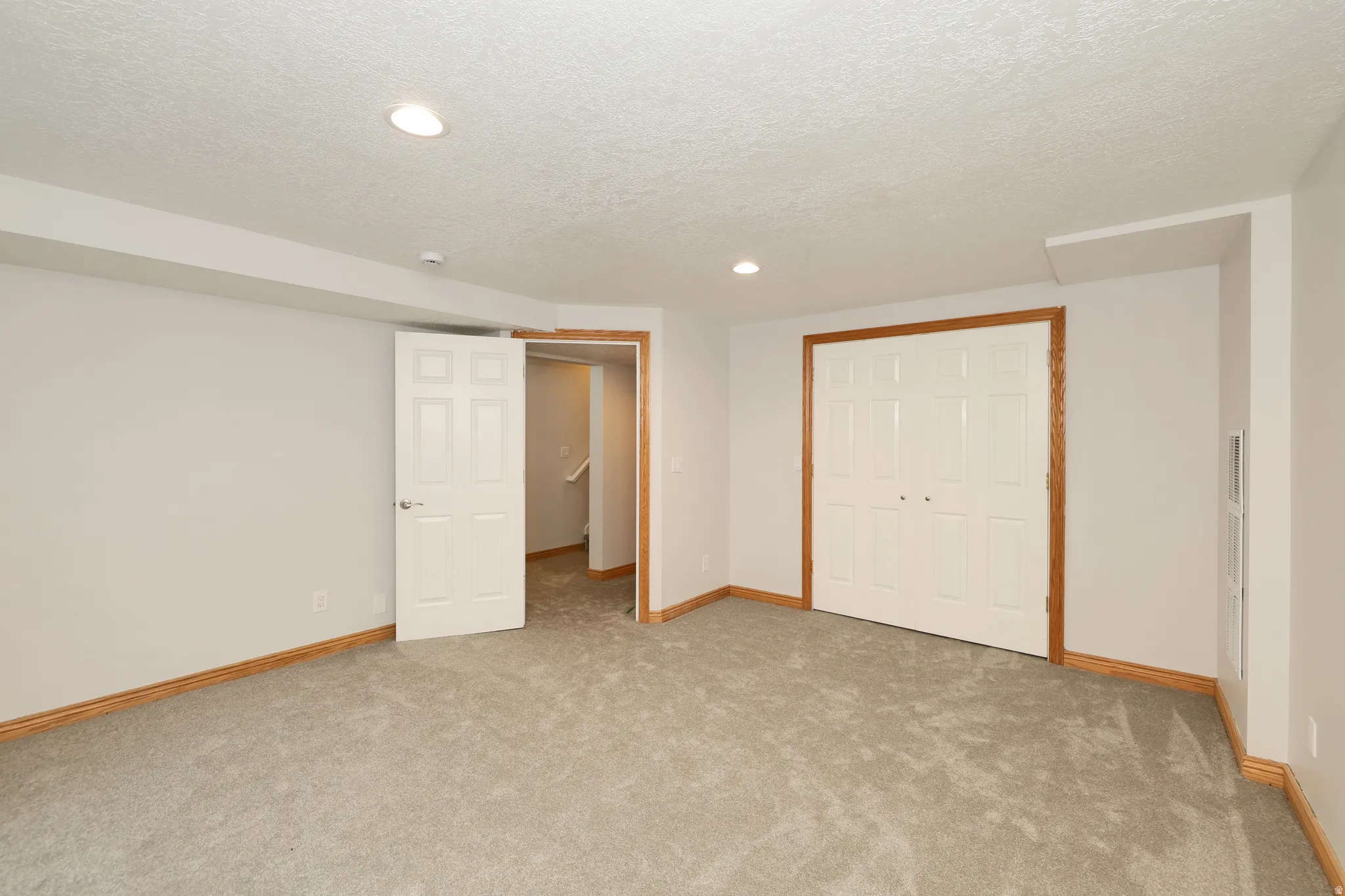 Carpeted room with recessed lighting and neutral wall tones