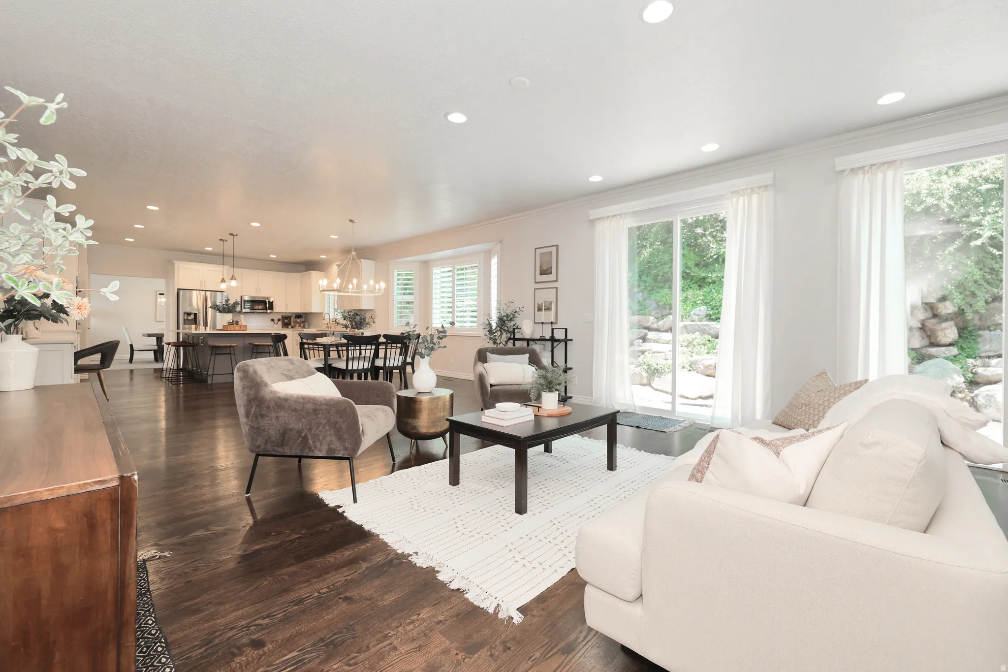 Open-concept living area with dark wood-finish flooring, recessed lighting, and multiple sliding glass doors